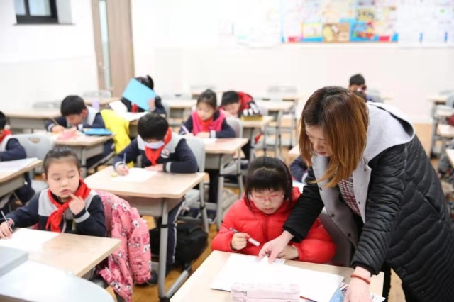 静安区第一中心小学教师轮流看护学生在校完成作业。校方供图